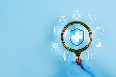 Close-up of a magnifying glass held in a hand, focusing on a medical icon, symbolizing thorough examination and precise diagnosis in healthcare, over a medical cross icon.の写真素材