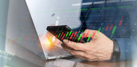 Investors use laptops to analyze stock market, investment strategies. and business growth analysis,...