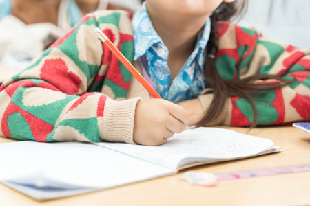 Girl taking notes in the classroom. Portrait of a young girl writing in her diary. Boy (8-9) writing...