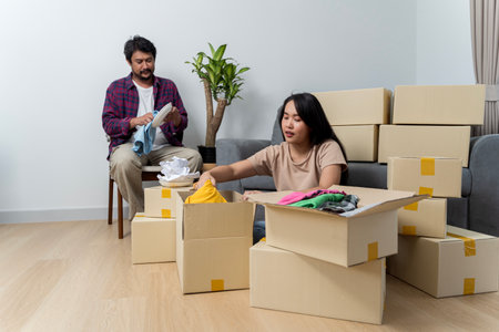 Creating lasting memories in their new nest. Happy young family couple renters tenants engaged in...