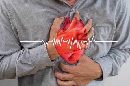 Heart in mans hand illness Cardiovascular diseases. Man was suffering from painful chest pain from a chronic disease. Man experiencing chest pain or discomfort, heartburn or heart attack conceptの写真素材