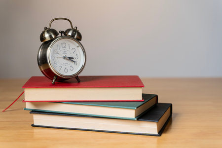 Alarm clock on books. Books and alarm clock on table, education concept.