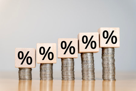 Stacks of Coins Money with Up Arrow and Percent Sign. Interest Rate. Financial concept image featuring wooden blocks with percentage symbols and a stack of coins.の写真素材