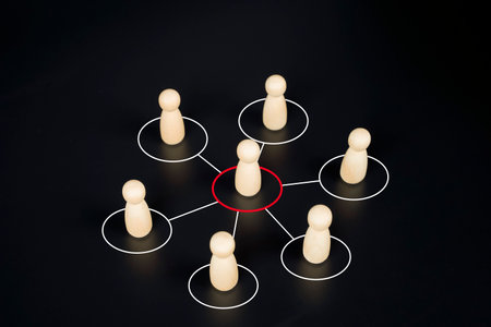 Wooden figures connected in a network, showing concept of leadership, teamwork, communication, and...
