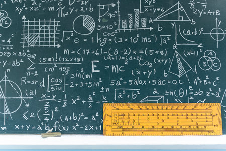 Educational blackboard in classroom filled with math and science formulas, graphs and equations,...