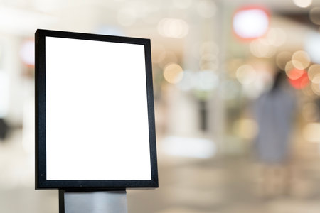 Blank signage mockup with black frame isolated on blurred shopping mall background, empty advertising or promotional display board template for marketing, branding, and creative design presentations.の写真素材