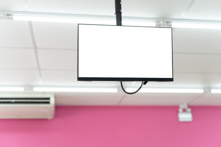Blank digital screen hanging from the ceiling in a retail space with bright lighting and pink background, ideal for advertising mockups, signage displays, marketing content, and promotional designs.の写真素材