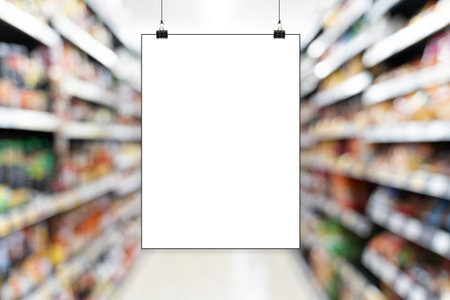 Blank poster hanging in a supermarket aisle, perfect for advertising, promotions, product display, branding and marketing mockups. Ideal for themes of retail, commercial announcements and sales eventsの写真素材