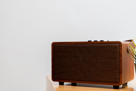 Retro wooden speaker placed on a minimalist table, showcasing warm texture and modern functionality. Ideal for themes of home decor, audio technology, lifestyle, and interior design.の写真素材