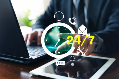 Businessman using laptop and tablet with 24/7 customer support icons. Concept of call center, help...