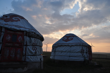mongolia yurts at grassland under sunsetの写真素材