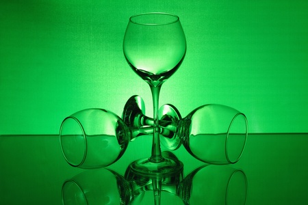 Three wineglasses with a green light on the mirrorの写真素材