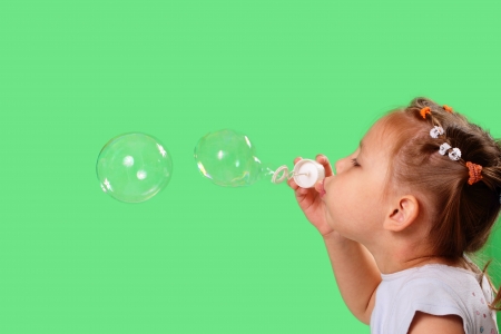 Pretty little girl blowing soap bubblesの写真素材