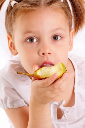 Attractive little girl eating pearの写真素材