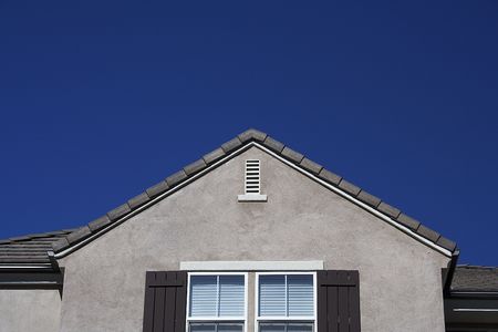 the top of a house with blue sky in the background.の写真素材