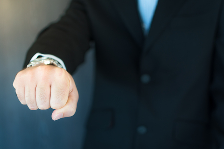 A young executive extending his arm and fist pumpingの写真素材