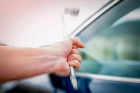 A troubled young person breaking into a car with a crowbar