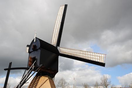 A dutch windmill just before the storm hits the land. 