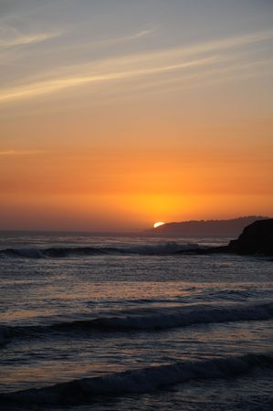 A warm sunset over a calm pacific oceanの写真素材
