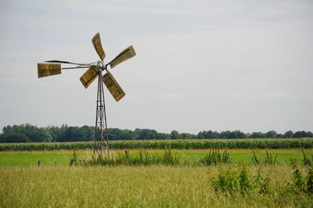 Windmill on a pole in a green meadowの写真素材