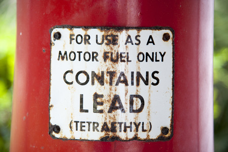 Old vintage rusty fuel pump sign on red poleの写真素材