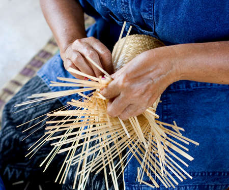 female hands manuallyweaving bamboo basketの写真素材