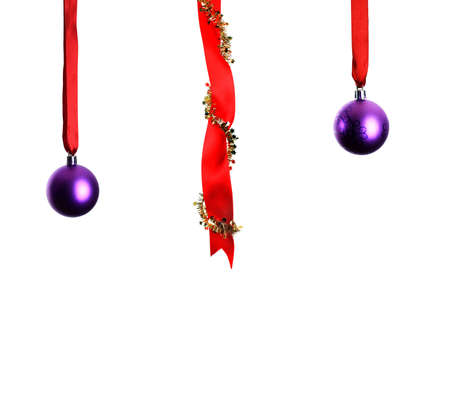 Christmas decoration with ribbons and baubles hanging over white background の写真素材