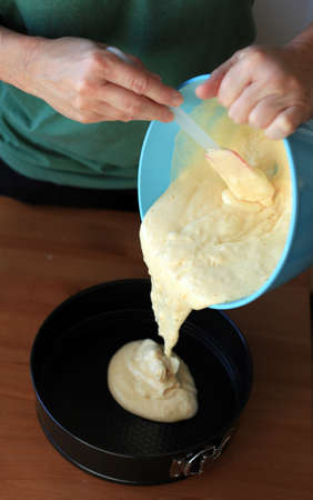 pouring thick cake batter into a cake panの写真素材