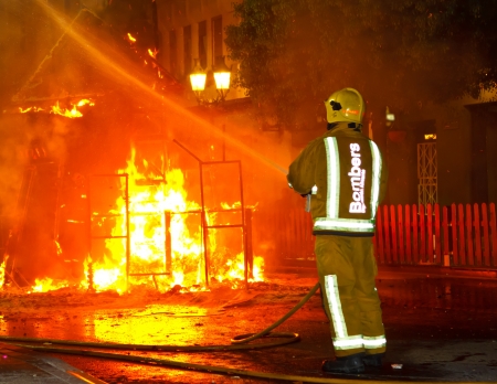 Firefighter putting out fire with water hose pressure