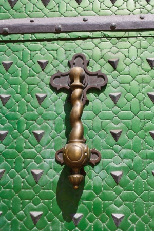 Old and Classic Golden Knocker on Green Metal Door with ornamentsの写真素材
