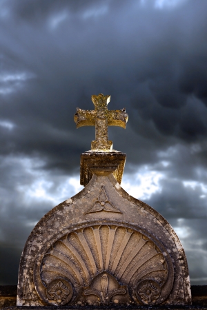 Stone cross on a grave in the cemetery with sky backgroundの写真素材