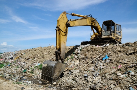 Backhoe at garbage dump with blue sky.の写真素材