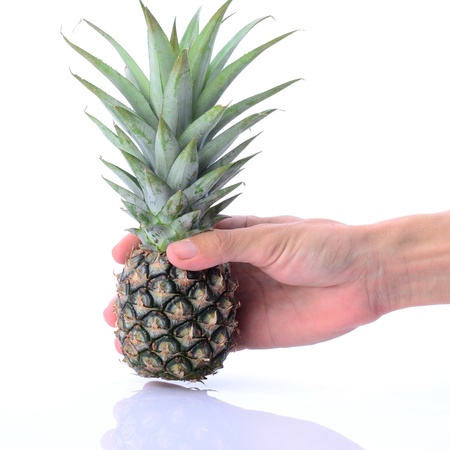 Man's hand picking up raw pinapple on whiteの写真素材