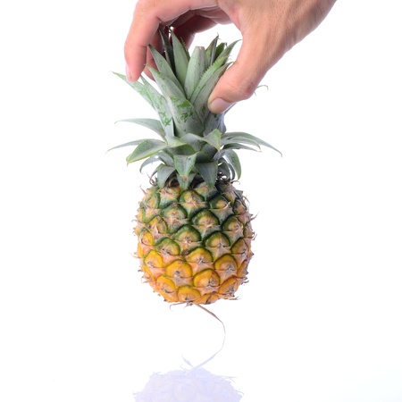 Man's hand picking up raw pinapple on whiteの写真素材