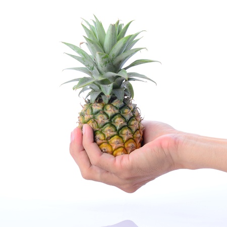 Hand holding pineapple in palmの写真素材