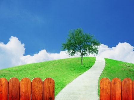 Buautiful green field and tranquil scene on white cloud, blue sky with tree, view over vintage wooden fenceの写真素材