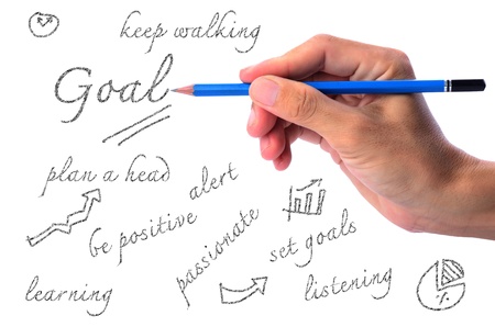 Man's hand holding pencil writing in goal conceptの写真素材