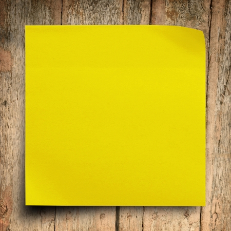 Yellow sticker paper note on vintage wood backgroundの写真素材