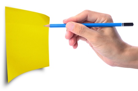 Man's hand holding pencil writing on blank yellow paper note, you can write your own text or your own design on paperの写真素材