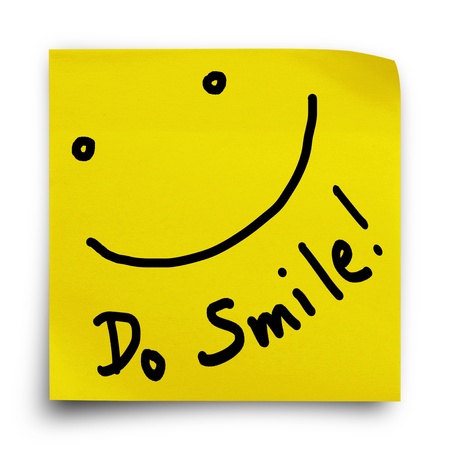Do smile with smiley face on yellow sticker paper note on white backgroundの写真素材