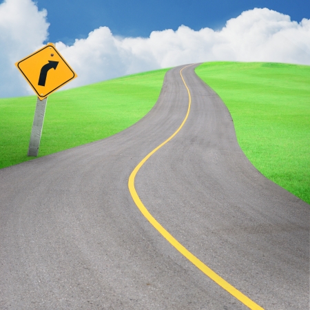 Long road with traffic signal, turn right, and beautiful green grass field, and  blue sky, abstract background.の写真素材