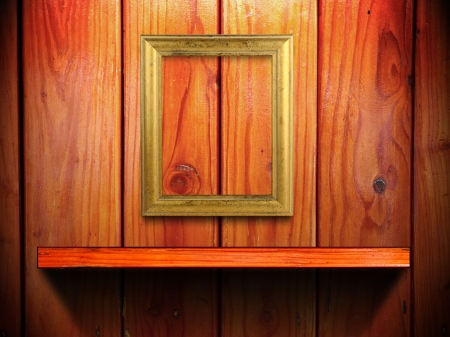 Classic golden frame on wood wall and shelf with light and shadowの写真素材