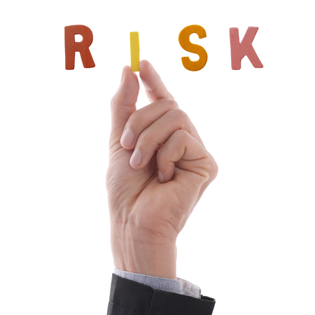 Business man's hand holding i alphabet to complete making word, risk. Business concept in risk situation.の写真素材