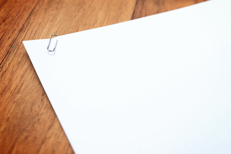 Close up of paperclip on white stacked paper, selective focus on paperclip.の写真素材
