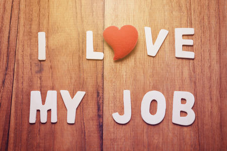 Alphabet letter with heart shape make text, I Love My Job, on wood table. Business concept in I love my job motivation, retro filter, vintage tone, and glow light effect.の写真素材