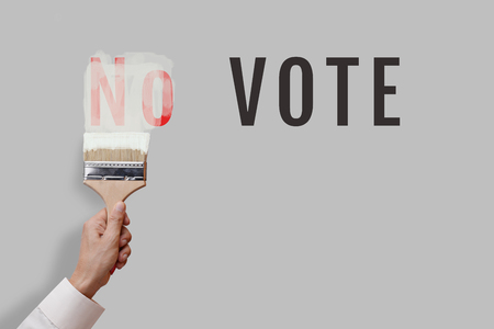 Man hand holding brush paint color on wall to erase message  No to have only Vote for concept of vote campaign. の写真素材