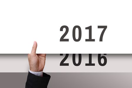Businessman's hand holding from under of white cardboard or paper new year2017 replace old year 2016. Blank space for your text, design, or copy space.の写真素材