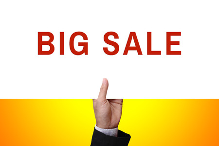 Businessman's hand holding from under of cardboard, white paper, poster, placard, frame, advertisement card, or banner with text BIG SALE.の写真素材