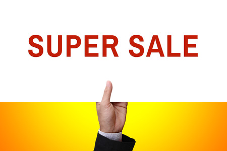 Businessman's hand holding from under of cardboard, white paper, poster, placard, frame, advertisement card, or banner with text SUPER SALE.の写真素材