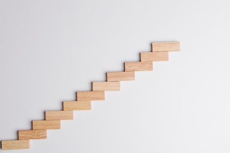 Wood block raising up in growing  statistics graph shape, top view on gray desk background with copy space. Business concept in growth economy.の写真素材